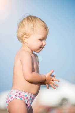 Şirin Bebek denize yakın kum plajındaki oyuncaklar ile oynama.