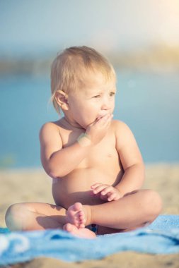 Şirin Bebek denize yakın kum plajındaki oyuncaklar ile oynama.
