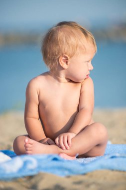 Şirin Bebek denize yakın kum plajındaki oyuncaklar ile oynama.