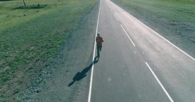 Mükemmel asfalt yolda sporcunun önünde alçak irtifa uçuşu.