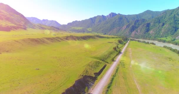 Camino de montaña rural aéreo y prado en la soleada mañana de verano. Autopista del asfalto y río. — Vídeos de Stock