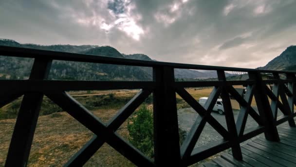 Тімелапс дерев'яного паркану на високій терасі в гірському пейзажі з хмарами. Горизонтальний рух повзунка — стокове відео