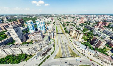 Kesişen yollar, evler, binalar, parklar ve otoparklar olan havacılık şehri manzarası. Güneşli yaz panoramik resmi