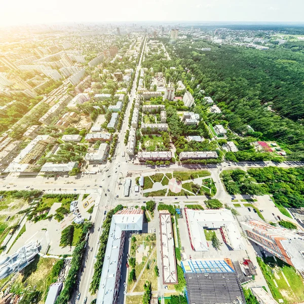 Vista aérea de la ciudad con encrucijadas y caminos, casas, edificios, parques y estacionamientos. Imagen panorámica soleada de verano — Foto de Stock