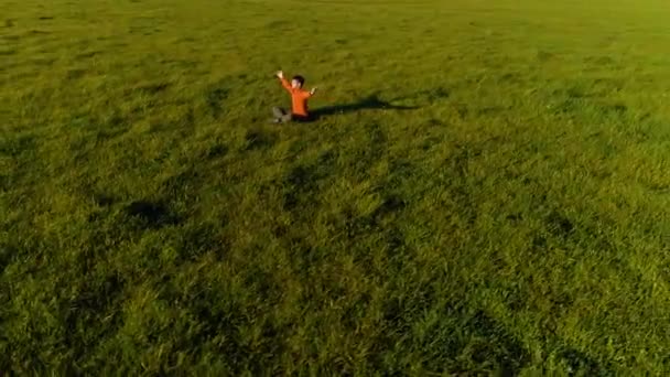 Volo radiale a bassa quota sopra lo sport yoga uomo a perfetta erba verde. Tramonto in montagna. — Video Stock