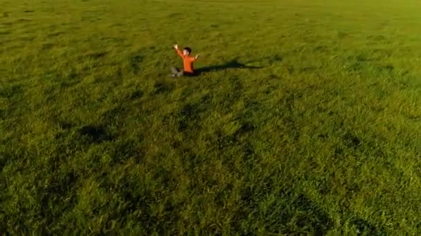 Lage hoogte radiale vlucht over sport yoga man op perfect groen gras. Zonsondergang in de bergen. — Stockvideo