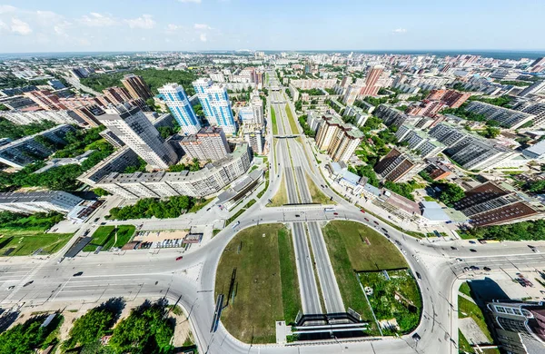 Letecký výhled na město s křižovatkou a silnic, domů, budov, parků a parkovišť. Slunečné léto panoramatický obraz — Stock fotografie