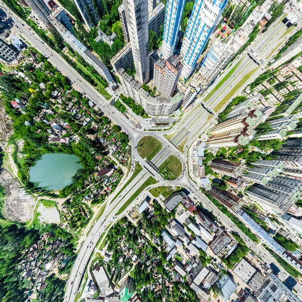 Vista aérea de la ciudad con encrucijadas y caminos, casas, edificios, parques y estacionamientos. Imagen panorámica soleada de verano — Foto de Stock