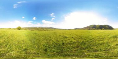 360 VR 'lık güzel bir dağ çayırı zaman dilimi. Yaz ya da sonbahar zamanında. Bulutlar, yeşil çimenler ve güneş ışınları.