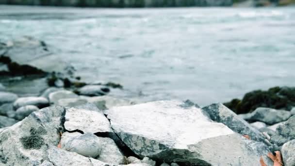 Dolly slider shot of the splashing water in a mountain river near forest. Rochers humides et rayons du soleil. Mouvement horizontal régulier. — Video