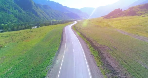 Vuelo sobre carretera asfaltada montaña carretera y prado — Vídeos de Stock