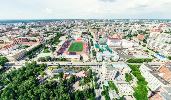 Uitzicht op de stad vanuit de lucht met kruispunten en wegen, huizen, gebouwen, parken en parkeerplaatsen. Zonnige zomer panoramisch beeld — Stockfoto