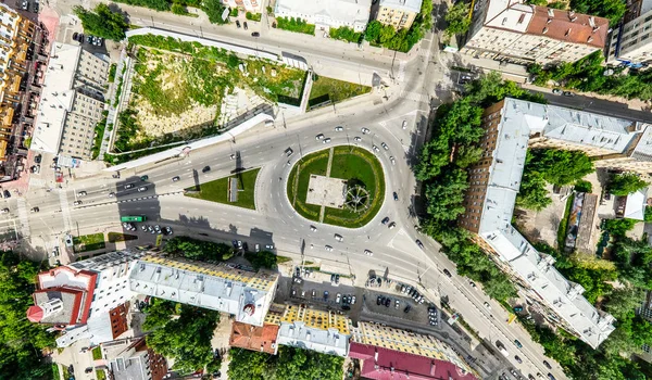 Vista aérea de la ciudad con encrucijadas y caminos, casas, edificios, parques y estacionamientos. Imagen panorámica soleada de verano — Foto de Stock