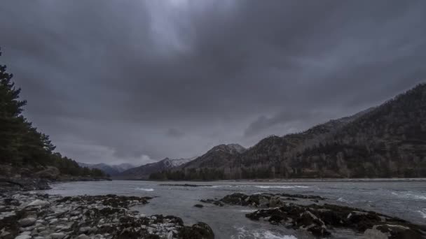 Tijdsverloop schot van een rivier in de buurt van bergbos. Enorme rotsen en snelle wolken. — Stockvideo