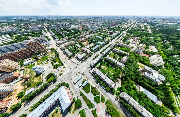 Vista aérea de la ciudad con encrucijadas y caminos, casas, edificios, parques y estacionamientos. Imagen panorámica soleada de verano —  Fotos de Stock
