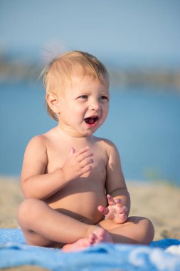 Şirin Bebek denize yakın kum plajındaki oyuncaklar ile oynama.