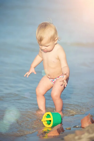 Carino bambino che gioca sulla spiaggia di sabbia e in acqua di mare . — Foto Stock