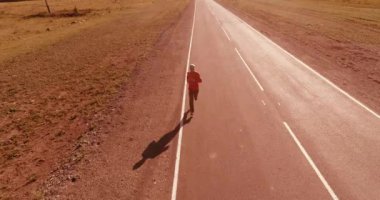 Mükemmel asfalt yolda sporcunun önünde alçak irtifa uçuşu.