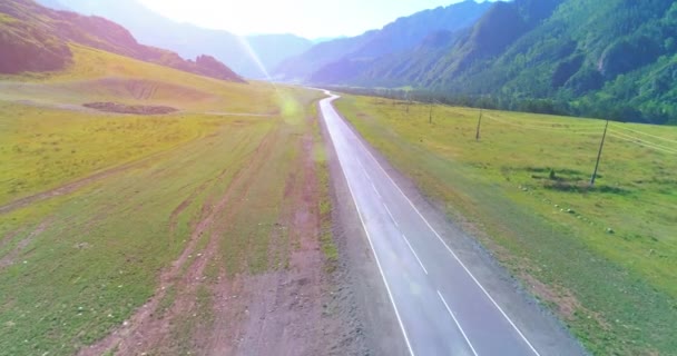 Vuelo sobre carretera asfaltada montaña carretera y prado — Vídeo de stock