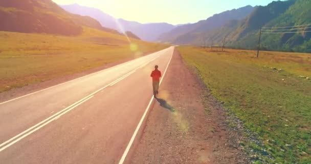 Volo a bassa quota di fronte all'uomo sportivo in perfetta strada asfaltata — Video Stock