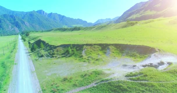 Luchtfoto landelijke bergweg en weide op zonnige zomerochtend. Asfaltweg en rivier. — Stockvideo