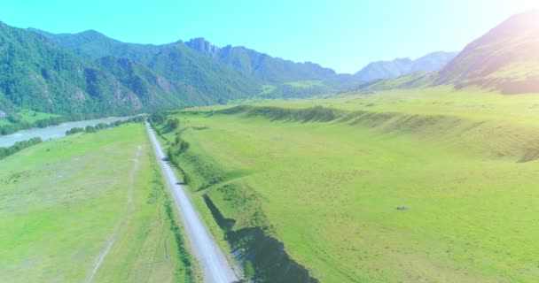 Letecká horská cesta a louka za slunečného letního rána. Asfaltová dálnice a řeka. — Stock video