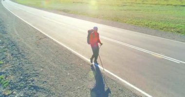 Asfalt yolda yürüyen otostopçu turist üzerinden uçuş. Yaz günü büyük bir kırsal vadi. Sırt çantalı gezgin..