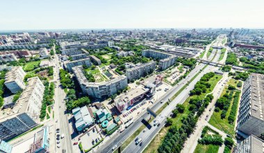 Kesişen yollar, evler, binalar, parklar ve otoparklar olan havacılık şehri manzarası. Güneşli yaz panoramik resmi