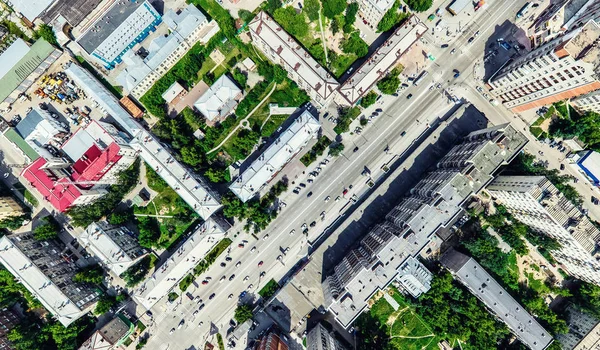 Vista aérea de la ciudad con encrucijadas y caminos, casas, edificios, parques y estacionamientos. Imagen panorámica soleada de verano — Foto de Stock