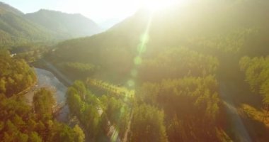 Güneşli yaz sabahında taze dağ nehri ve çayır üzerinde uçuşun ortasında. Aşağıdaki kırsal toprak yol.