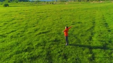 Yeşil çimlerde spor yogacısı üzerinde alçak irtifa radyal uçuş. Dağda gün batımı.