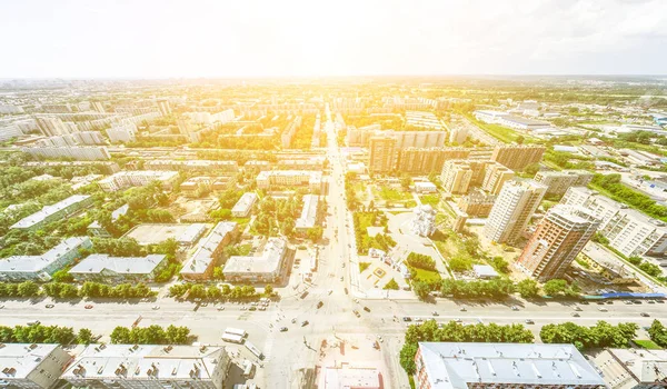 Vista aérea de la ciudad con encrucijadas y caminos, casas, edificios, parques y estacionamientos. Imagen panorámica soleada de verano — Foto de Stock