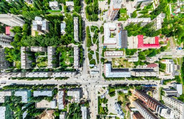 Kesişen yollar, evler, binalar, parklar, otoparklar, köprüler olan havacılık şehri manzarası. Helikopter insansız hava aracı atışı. Geniş Panoramik resim.