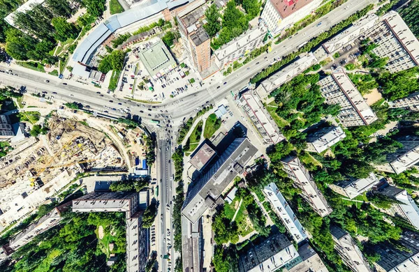 Vista aérea de la ciudad con encrucijadas y caminos, casas, edificios, parques y estacionamientos. Imagen panorámica soleada de verano —  Fotos de Stock