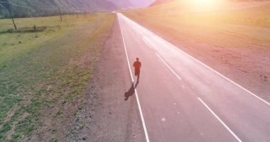 Mükemmel asfalt yolda sporcunun önünde alçak irtifa uçuşu.