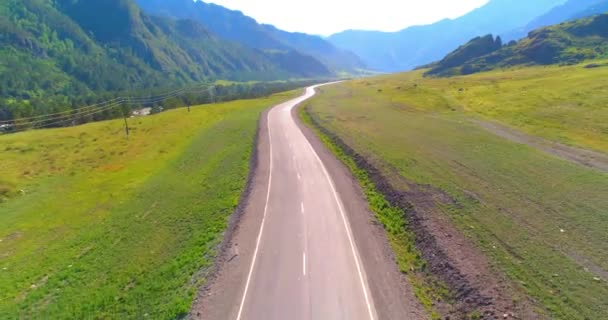 Vuelo sobre carretera asfaltada montaña carretera y prado — Vídeos de Stock