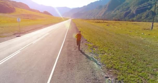 Mükemmel asfalt yolda sporcunun önünde alçak irtifa uçuşu. — Stok video