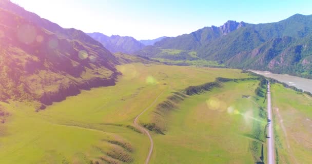 Aerea strada di montagna rurale e prato al sole mattina d'estate. Autostrada asfaltata e fiume. — Video Stock