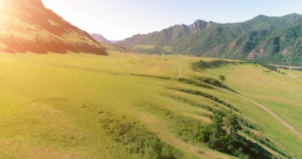 Estrada de montanha rural aérea e prado na manhã de verão ensolarada. Estrada de asfalto e rio. — Vídeo de Stock