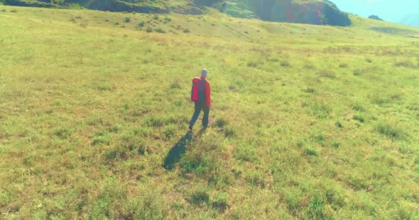 Let nad batohem turistické procházky přes zelené horské pole. Obrovské venkovské údolí v letní den. — Stock video