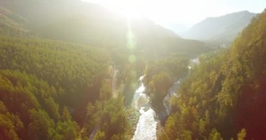 Güneşli yaz sabahında taze dağ nehri ve çayır üzerinde uçuşun ortasında. Aşağıdaki kırsal toprak yol.