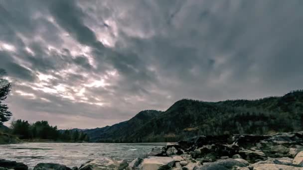 Временной снимок реки возле горного леса. Огромные камни и быстрые облака движутся. Горизонтальное скольжение — стоковое видео