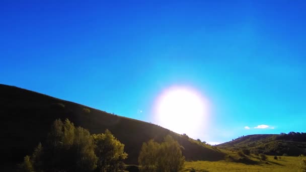 4K UHD prairie de montagne timelapse à l'été. Nuages, arbres, herbe verte et mouvement des rayons du soleil. — Video