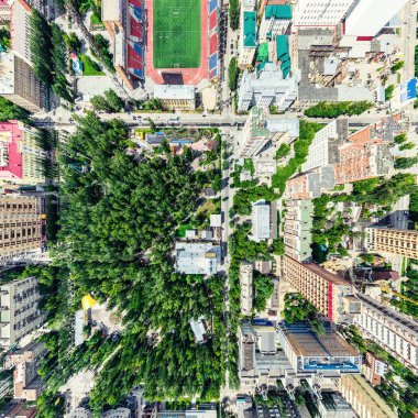 Kesişen yollar, evler, binalar, parklar ve otoparklar olan havacılık şehri manzarası. Güneşli yaz panoramik resmi