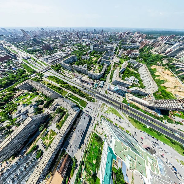 Vista aérea de la ciudad con encrucijadas y caminos, casas, edificios, parques y estacionamientos. Imagen panorámica soleada de verano —  Fotos de Stock