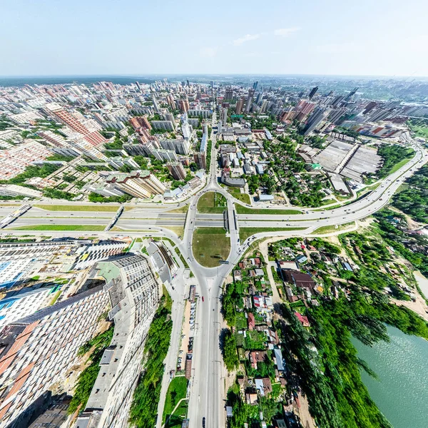Vista aérea de la ciudad con encrucijadas y caminos, casas, edificios, parques y estacionamientos. Imagen panorámica soleada de verano — Foto de Stock