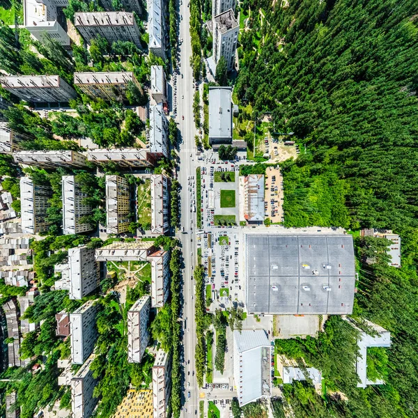 Vista aérea de la ciudad con encrucijadas y caminos, casas, edificios, parques y estacionamientos. Imagen panorámica soleada de verano —  Fotos de Stock