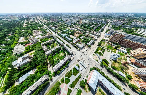 Vista aérea de la ciudad con encrucijadas y caminos, casas, edificios, parques y estacionamientos. Imagen panorámica soleada de verano —  Fotos de Stock