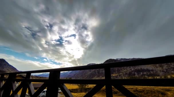 雲と山の風景の中に高いテラスで木製のフェンスのタイムラプス。水平スライダーの動き — ストック動画