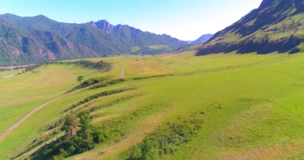 空中飞行 Aerial Uhd 在阳光充足的夏日早晨飞越乡间山路和草地 绿树和地平线上的阳光 免费的农村沥青公路和河流 — 图库视频影像